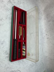 A 12-gauge shotgun cleaning kit in its original case. Italy